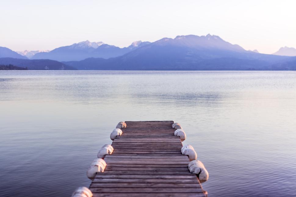 Free Image of Wooden pier extending into calm waters at sunset in tranquil landscape 
