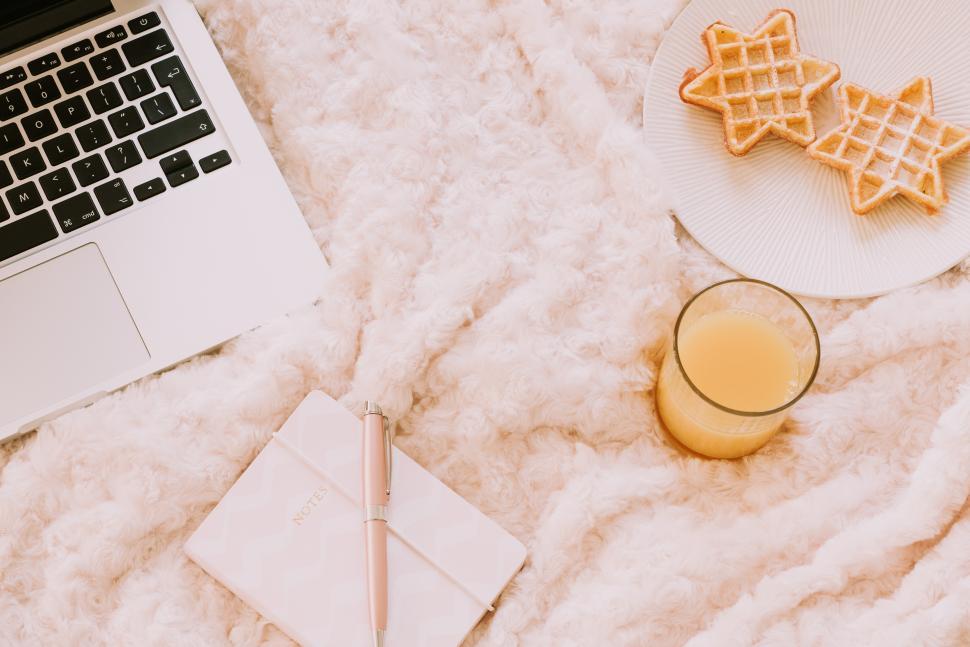 Free Image of Morning workspace with snacks and a drink on a cozy blanket 