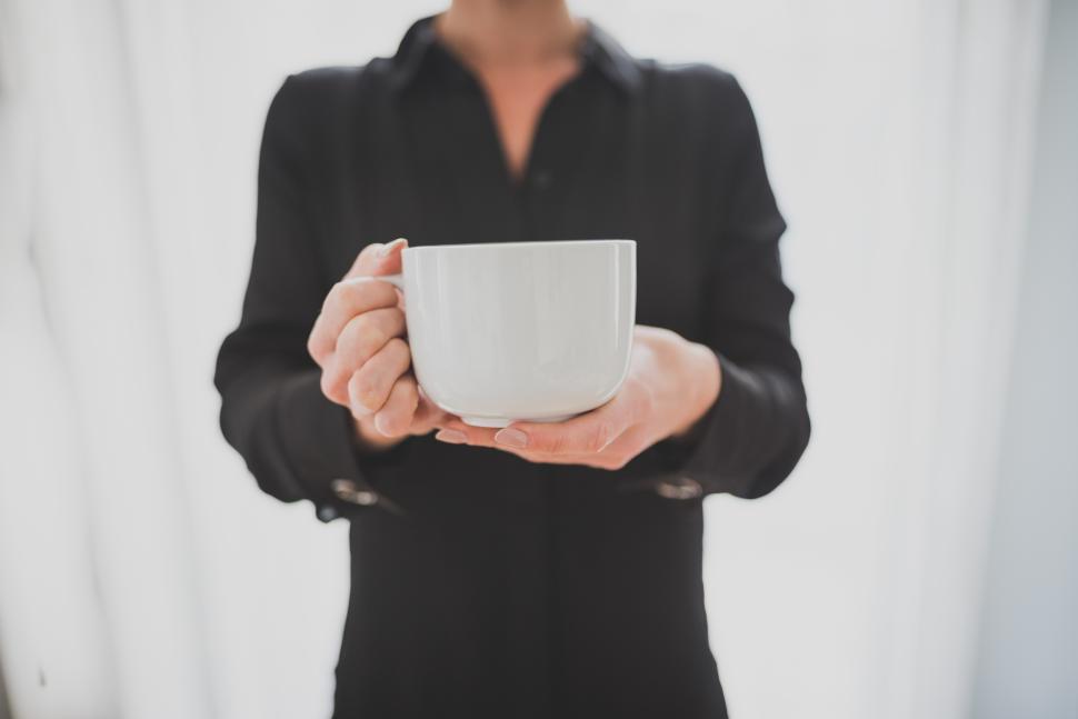 Free Image of Holding a warm cup in a relaxed office setting 