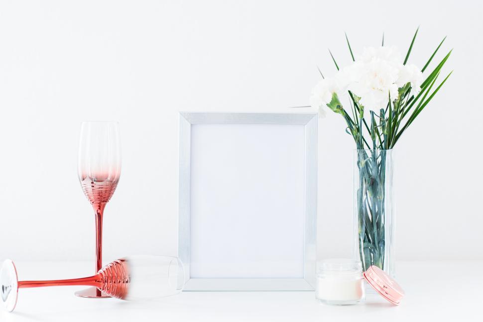 Free Image of Stylish table arrangement with flowers and empty frame 