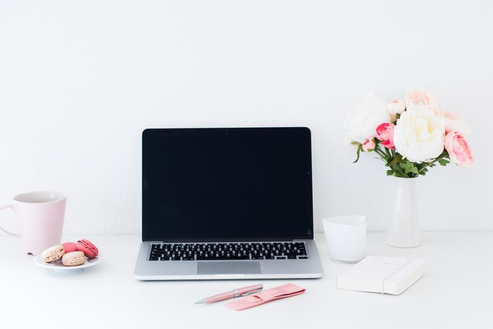 Free Image of Workspace with laptop and sweet treats in a cozy setting 