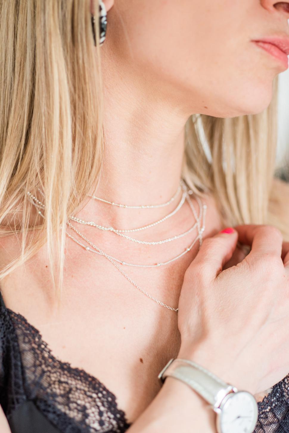 Free Image of Elegant woman showcasing layered necklaces and jewelry 