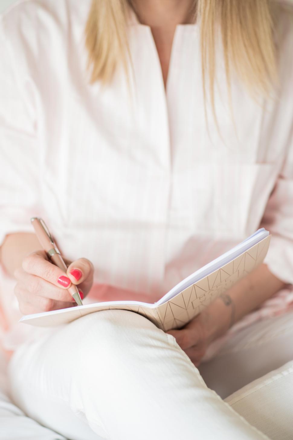 Free Image of Writing in a notebook during a quiet moment of reflection 