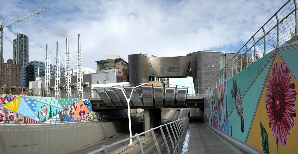Free Image of City landscape featuring modern architecture and vibrant murals near a waterway 