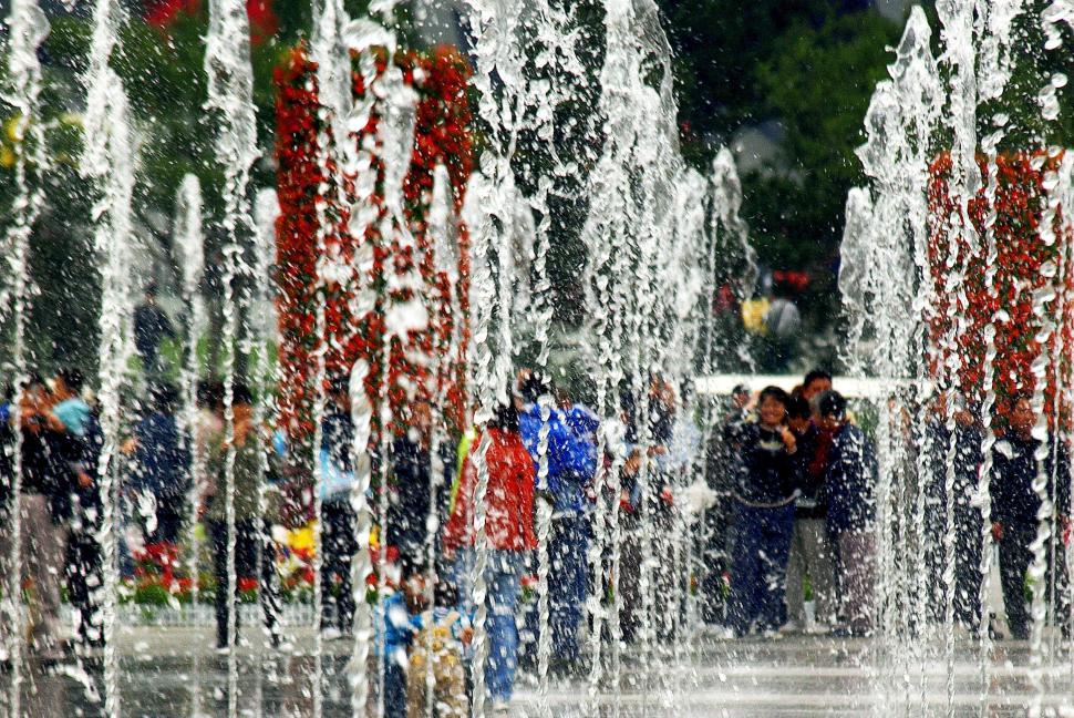 Free Image of People enjoying a vibrant fountain display in a park during the afternoon 