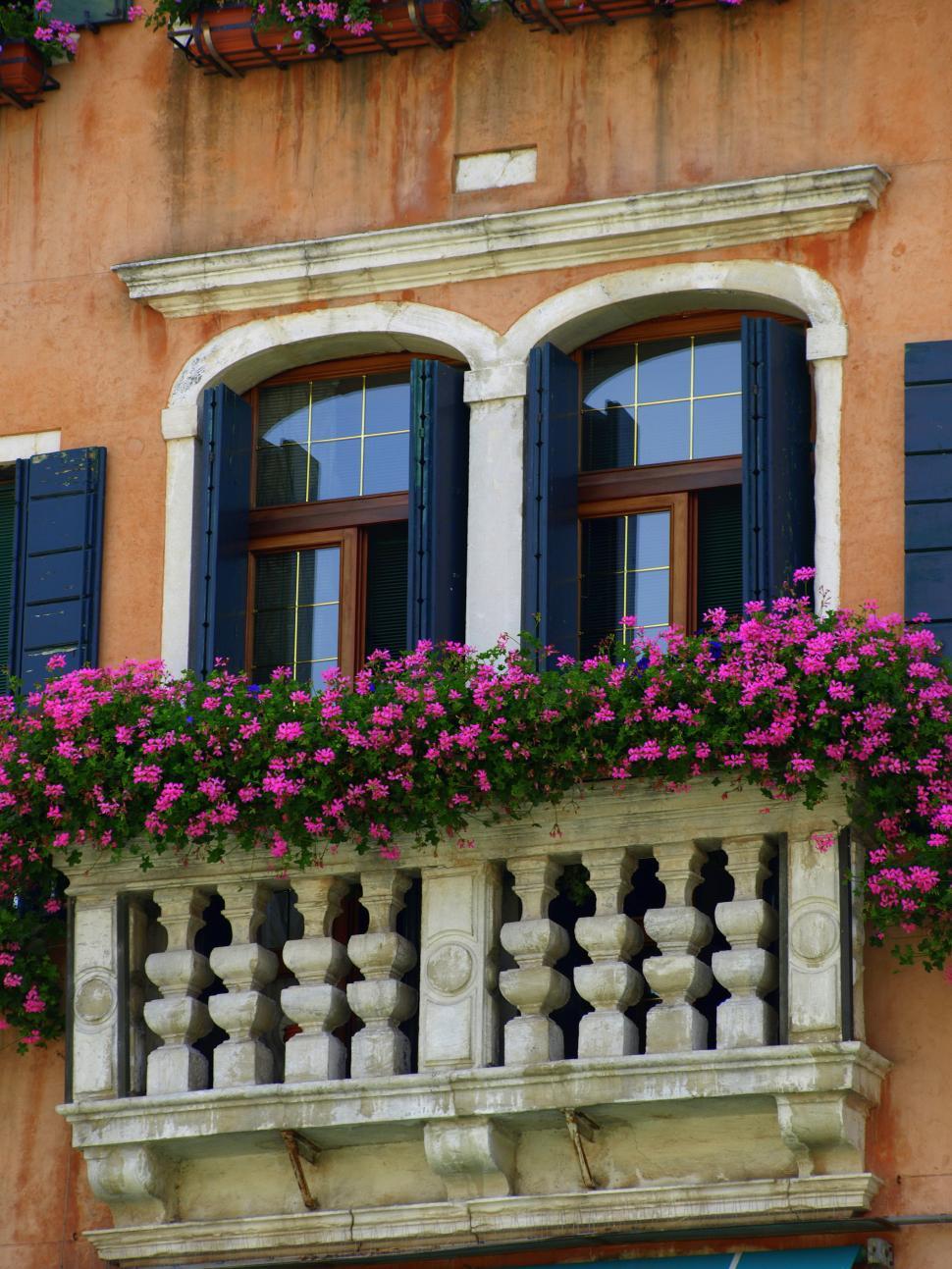 Free Image of Charming balcony adorned with vibrant flowers in an Italian town 