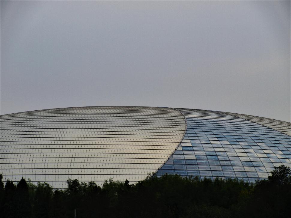 Free Image of Modern architectural design of a large glass-covered building in cloudy weather 