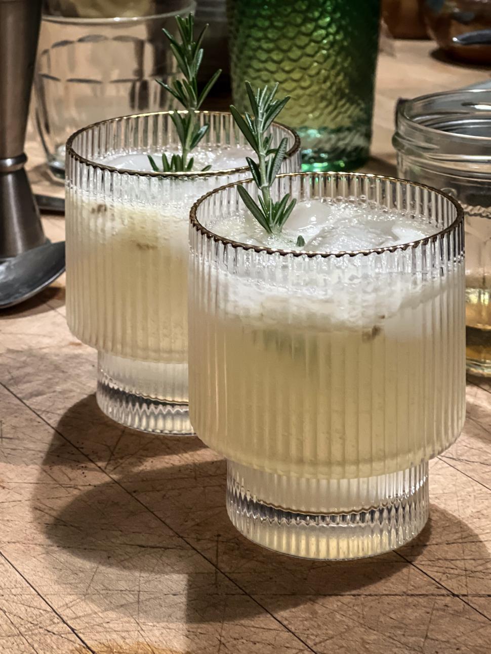 Free Image of Refreshing cocktails served in stylish glasses with rosemary garnish 