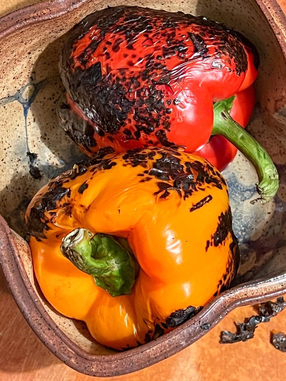 Free Image of Roasted peppers in a rustic dish on a wooden table surface 
