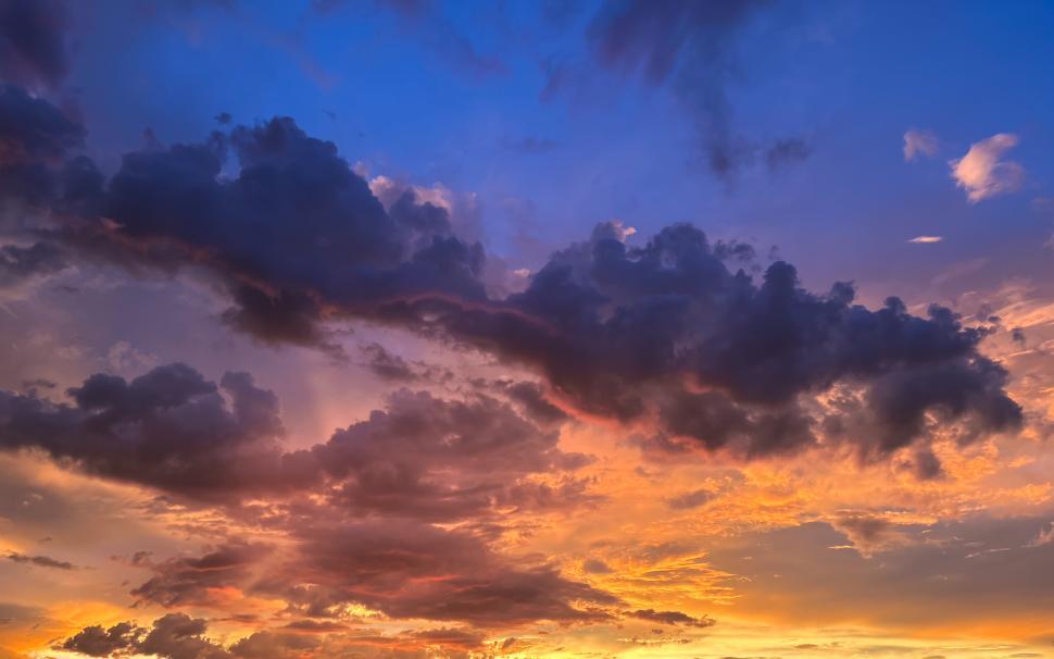 Free Image of Colorful sunset clouds filling the sky with vibrant hues at dusk 