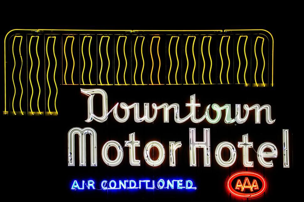Free Image of Downtown Motor Hotel neon sign glowing at night in a bustling urban area 