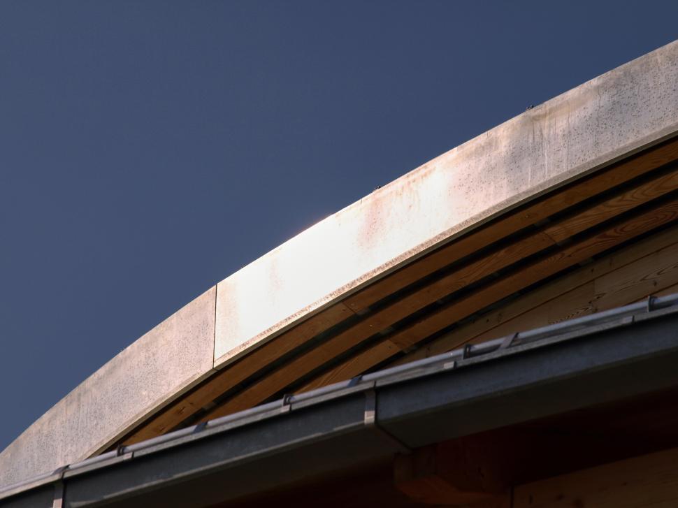 Free Image of Architectural detail of a modern building roof against a clear blue sky 