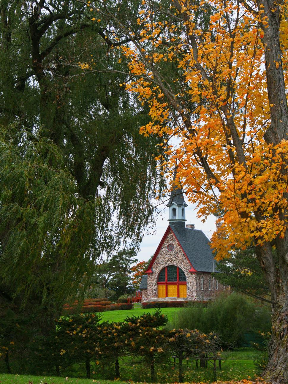 Free Image of Scenic fall view with a quaint church nestled among trees 