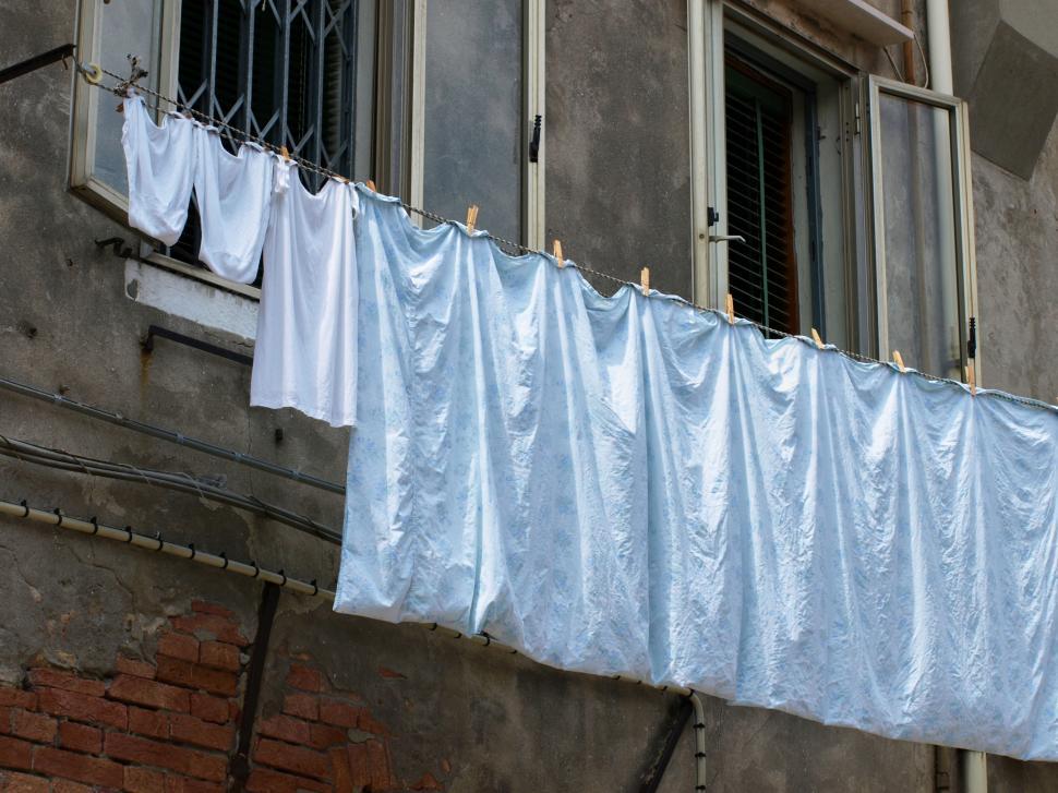 Free Image of Laundry hanging outside a window in an urban neighborhood setting 