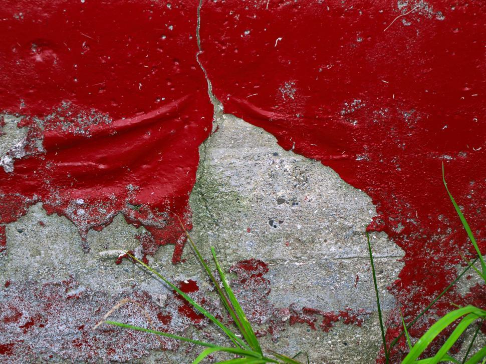 Free Image of Textured wall showing peeling red paint against a gray surface and grass 