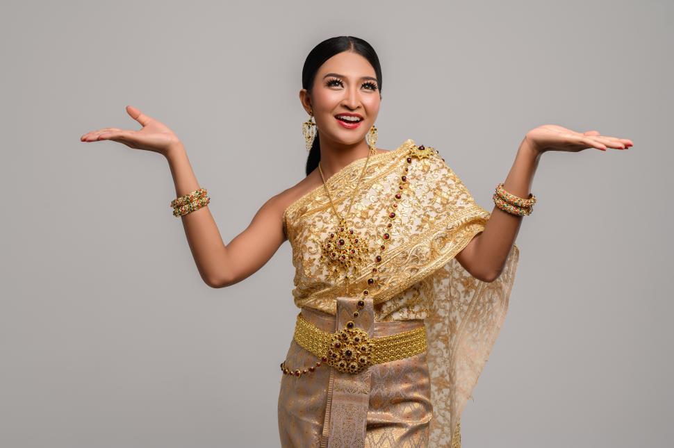 Free Image of women wear Thai clothes and open their hands on both sides. 