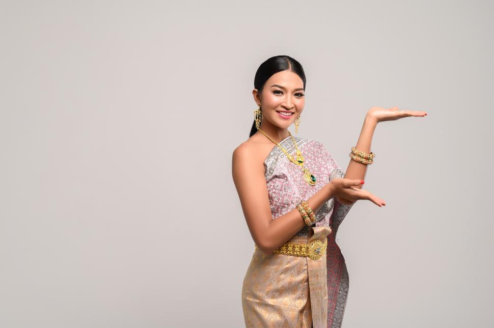 Free Image of Beautiful Thai women wear Thai clothes and open his hand to the left 