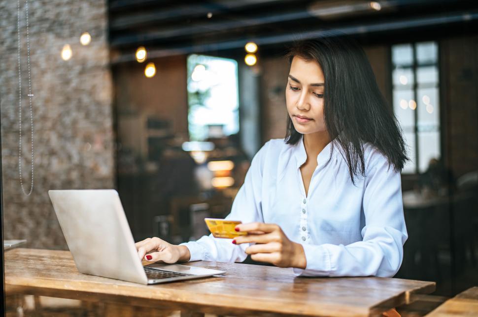 Free Image of woman sitting thinking about credit card balances,notebook. 