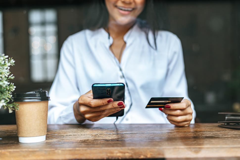 Free Image of Pay for goods by credit card through a smartphone in a coffee shop. 