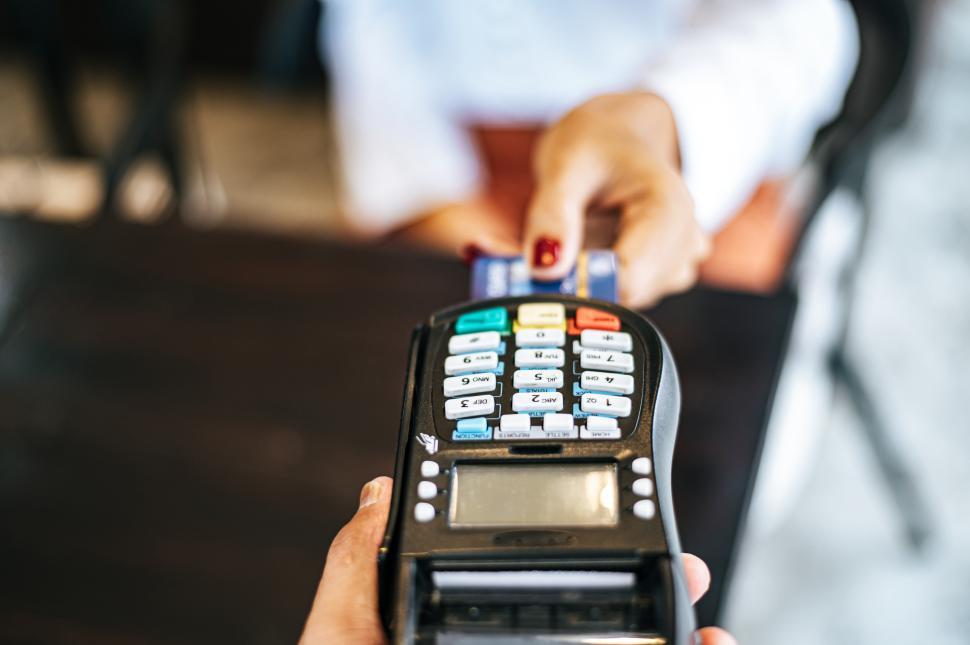 Free Image of Close-up image of woman paying with credit card in cafe 