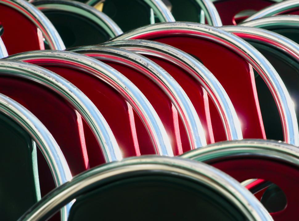 Free Image of Stacked red chairs with shiny metallic frames in a vibrant setting 