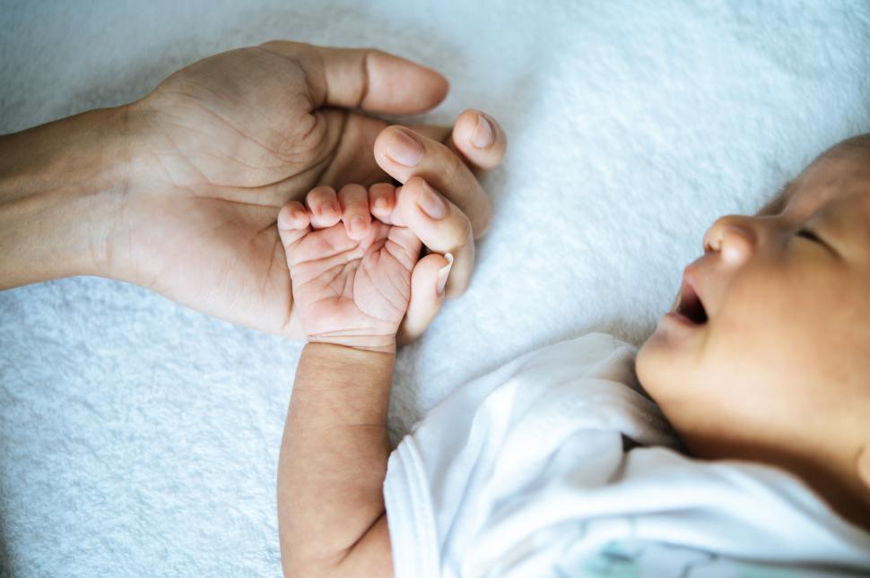 Free Image of The newborn baby sleeping and puts the hand on the mother s hand. 