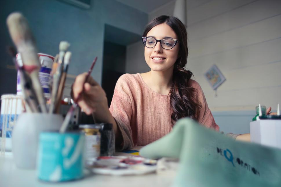 Free Image of Young woman painting creatively in a bright studio during the afternoon 