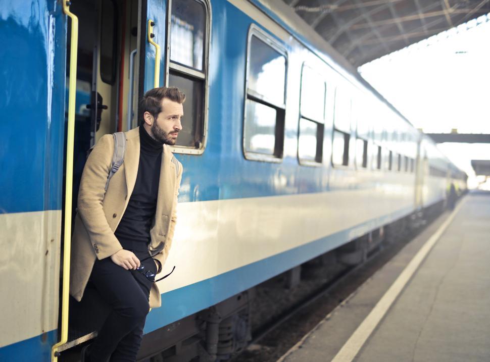 Free Image of Man waiting on train platform in stylish coat during daytime travel 