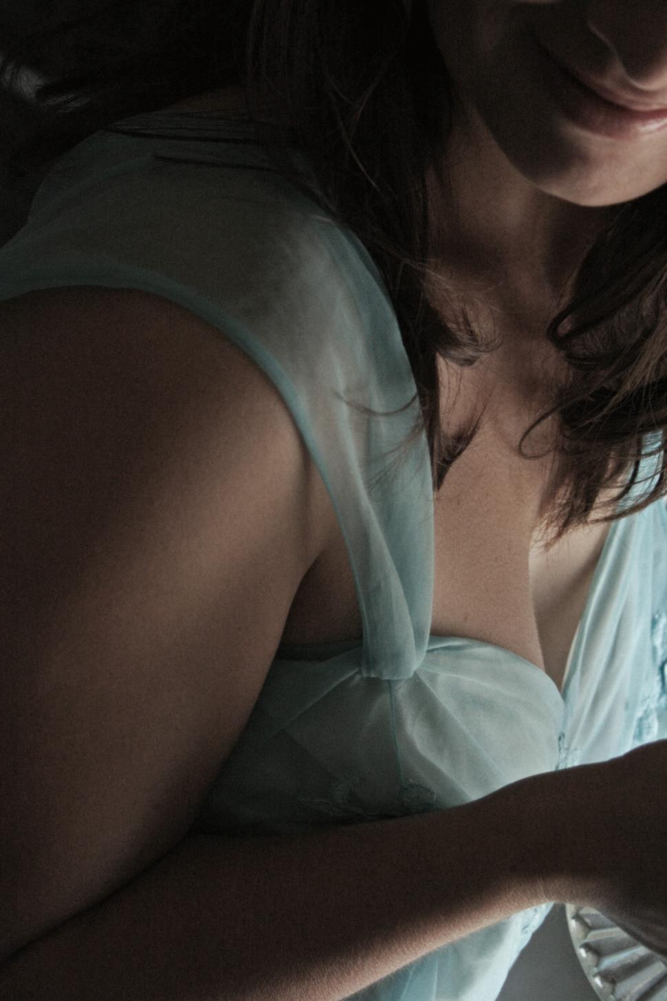 Free Image of Woman in soft blue dress relaxes at home with warm lighting in evening 
