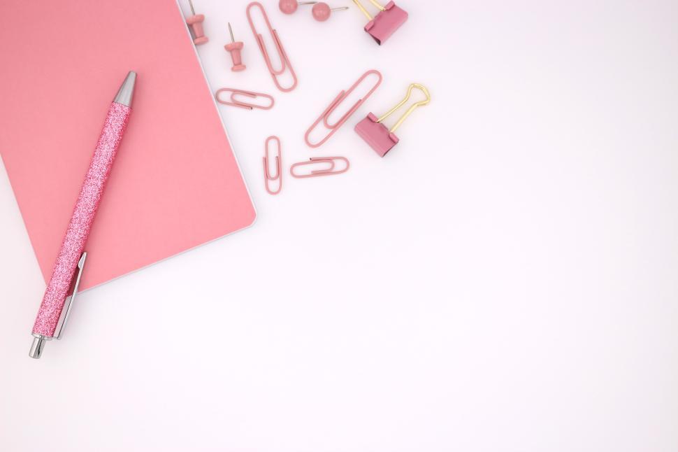 Free Image of Stationery collection including a pink notebook and various stationery items 