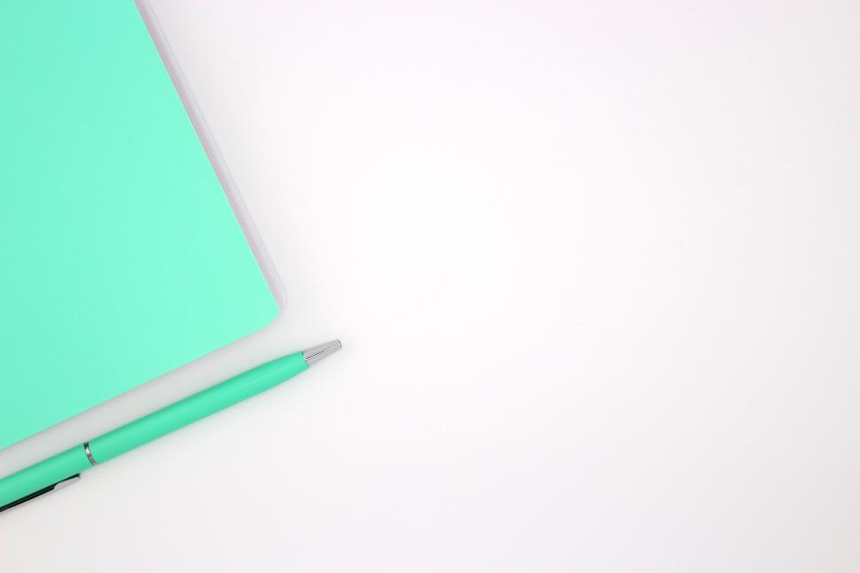 Free Image of Bright turquoise notebook and pen on clean workspace with minimalist design 