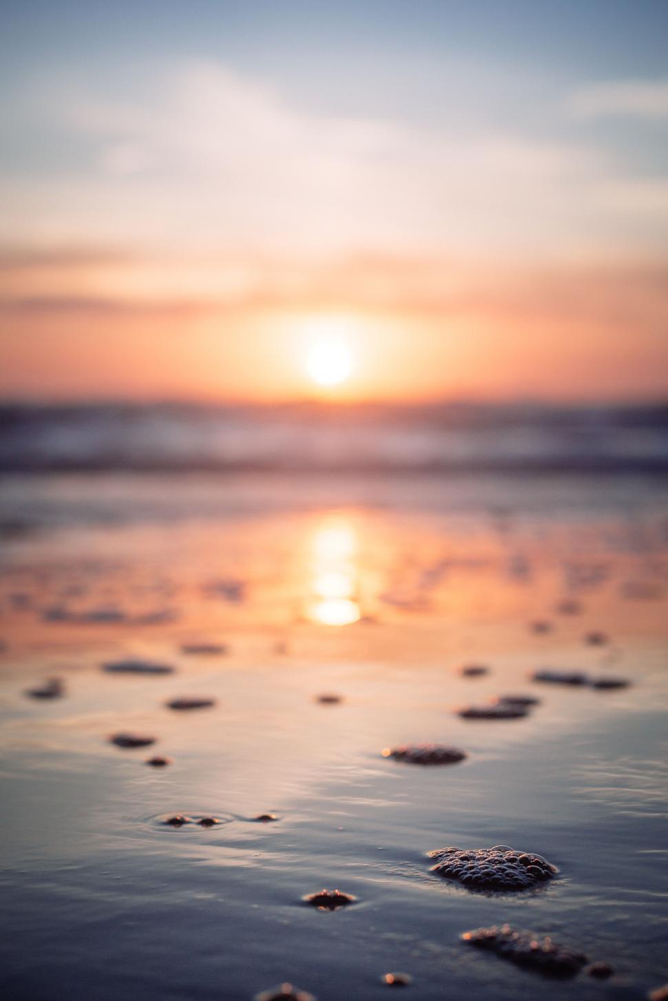 Free Image of Beautiful sunset reflecting on tranquil beach water at dusk 