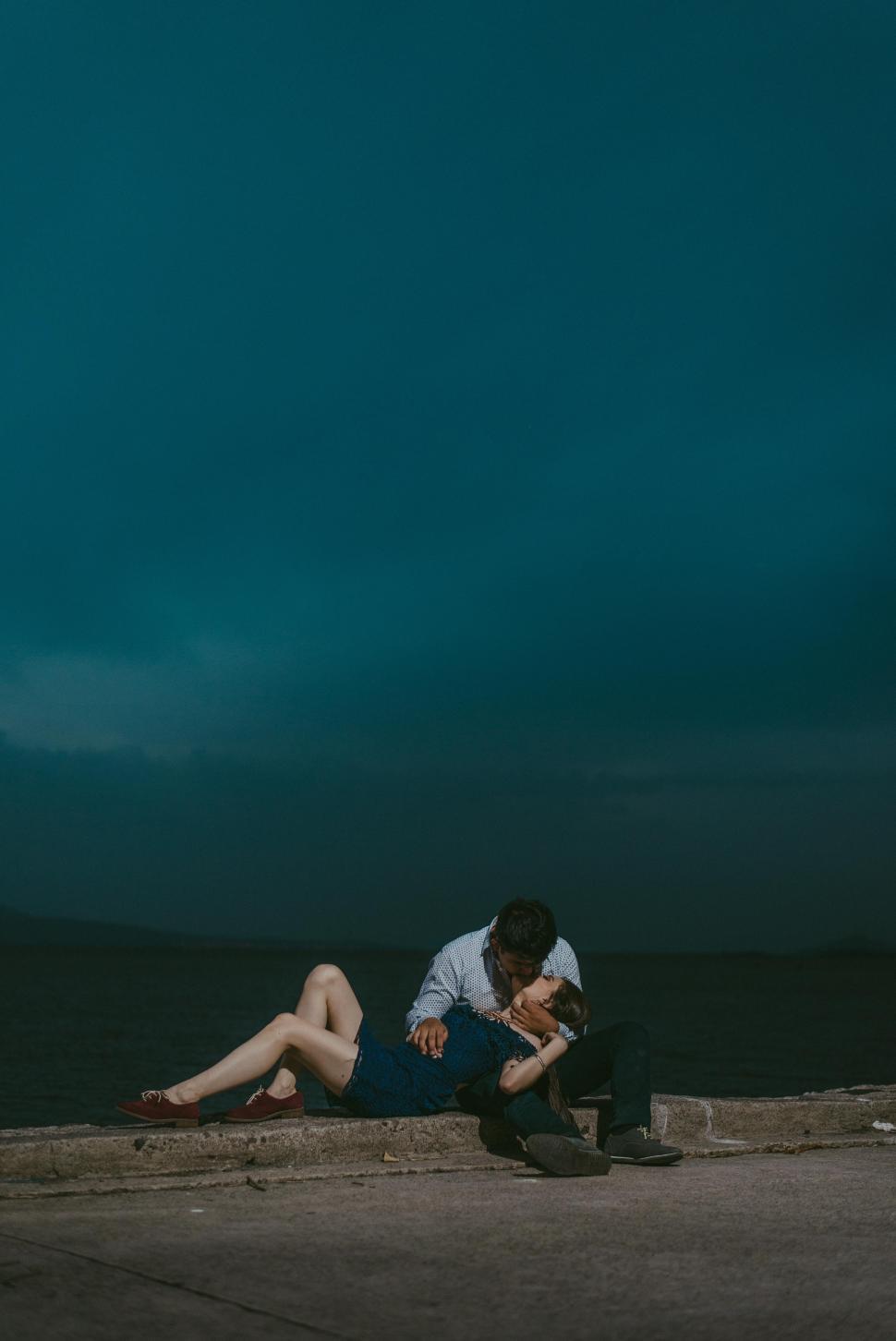 Free Image of Romantic couple sharing an intimate moment by the water at twilight 