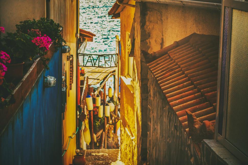 Free Image of Charming alleyway leading to a waterfront tavern 