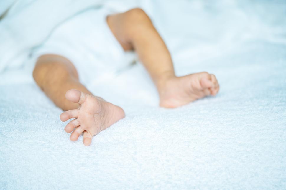 Free Image of Newborn baby feet on a white blanket. 