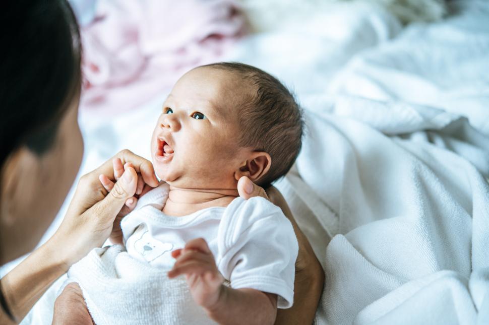 Free Image of Mother looking at the baby lying in the hands of the mother 