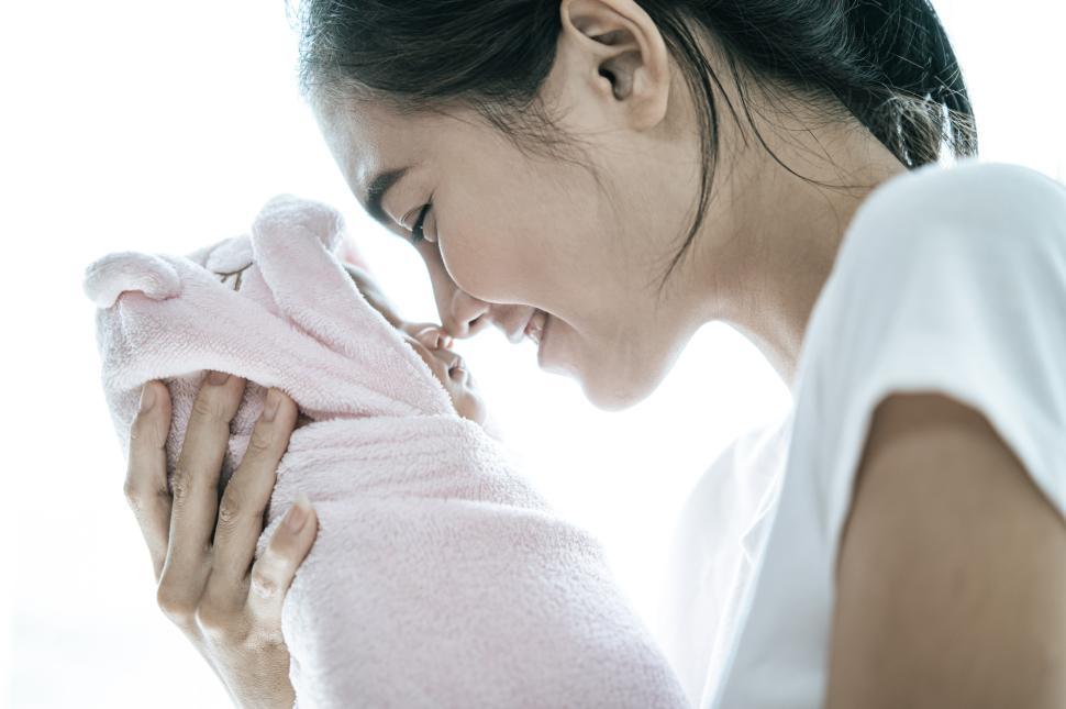 Free Image of The newborn baby sleeping in the hands of the mother 