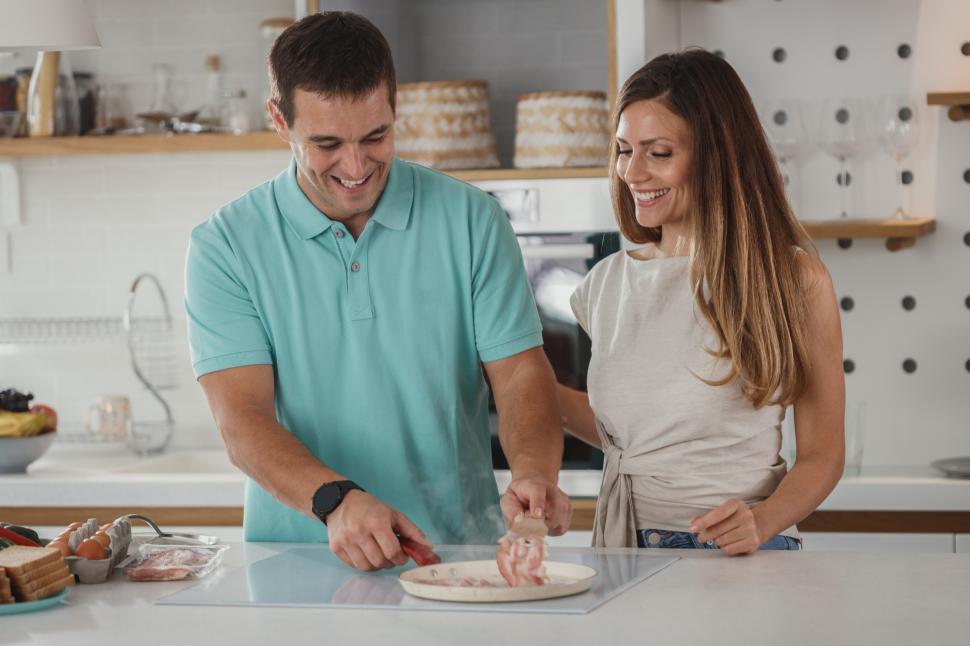 Free Image of Couple preparing a meal together in a modern kitchen setting 