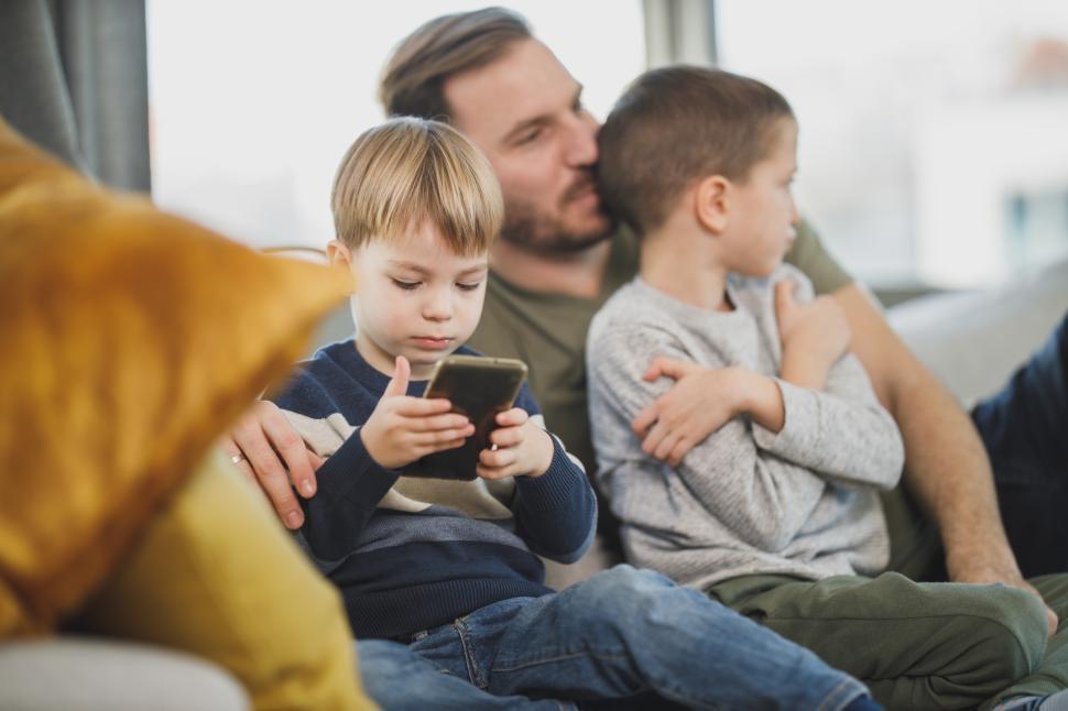 Free Image of Father and two children relaxing at home with smartphone 