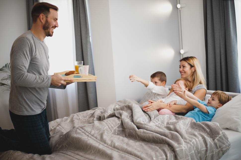 Free Image of Family enjoying breakfast together in cozy bedroom setting 