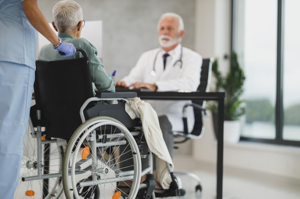 Free Image of Doctor consulting with elderly patient in a hospital setting 