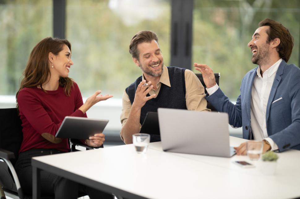 Free Image of Group of colleagues sharing a light moment in a modern office 