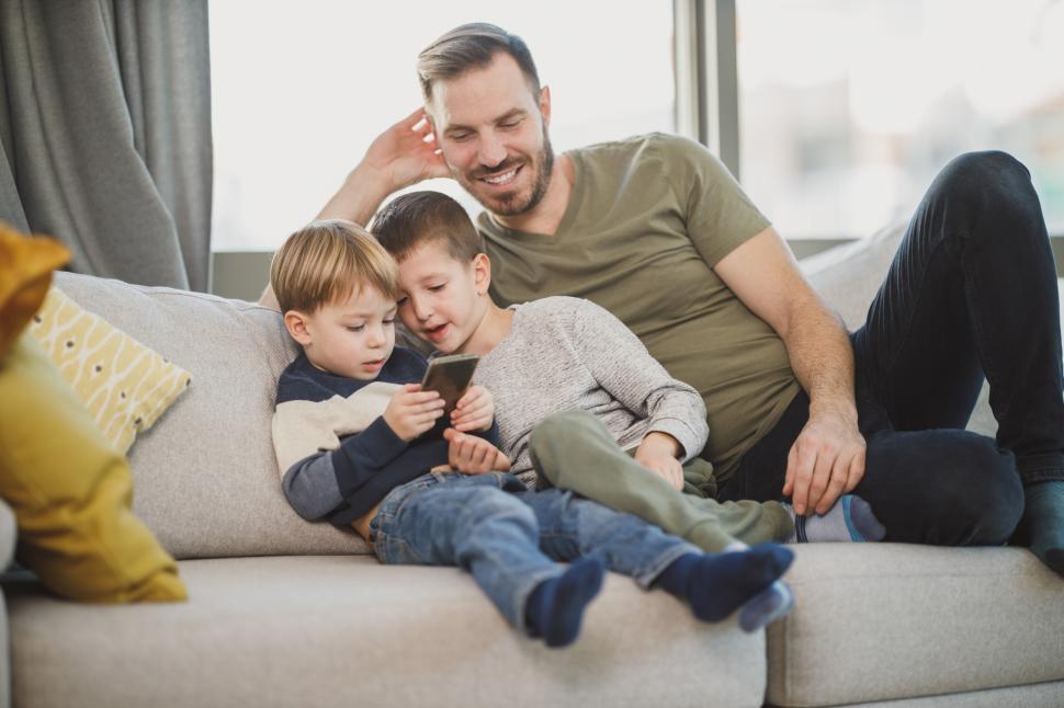 Free Image of Father and two children enjoying time together on the sofa 