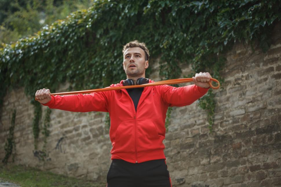 Free Image of Man exercises with resistance band in outdoor park setting 