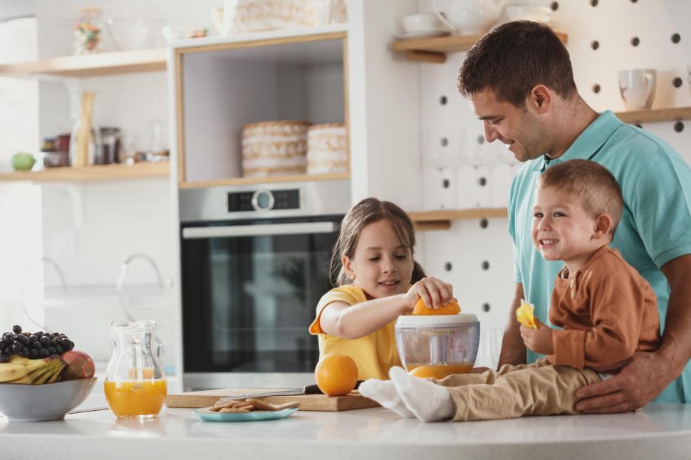 Free Image of Family making fresh juice in a bright kitchen on a sunny morning 
