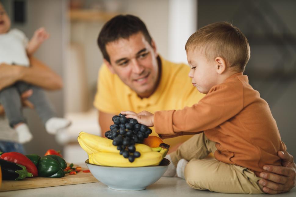 Free Image of Family enjoying fresh fruits together in a kitchen 