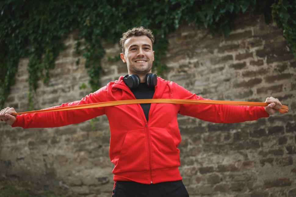 Free Image of Fitness enthusiast stretching with resistance band outdoors 