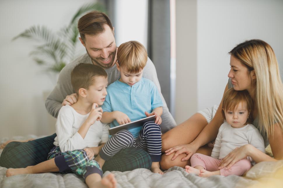 Free Image of Family enjoying a cozy time together while using a tablet indoors 