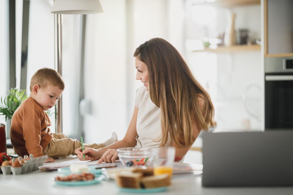 Free Image of Mother and son share a creative moment in the kitchen during daytime 