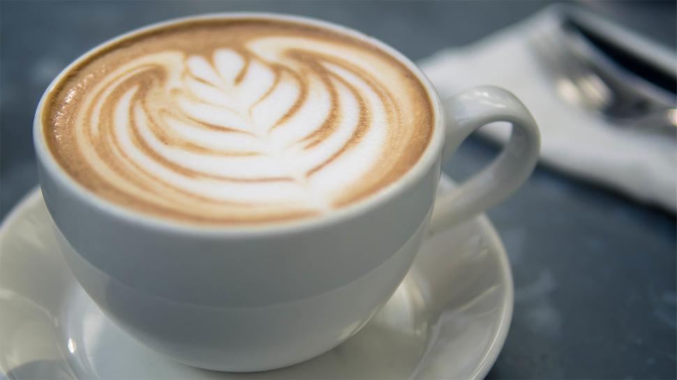 Free Image of Beautiful latte art in a cozy cafe setting 